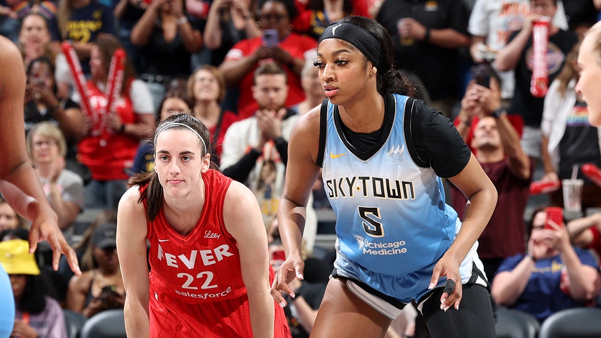 Caitlin Clark, #22 of the Indiana Fever, and Angel Reese, #5 of the Chicago Sky, look on during the game on June 1, 2024, at Gainbridge Fieldhouse in Indianapolis, Indiana. 