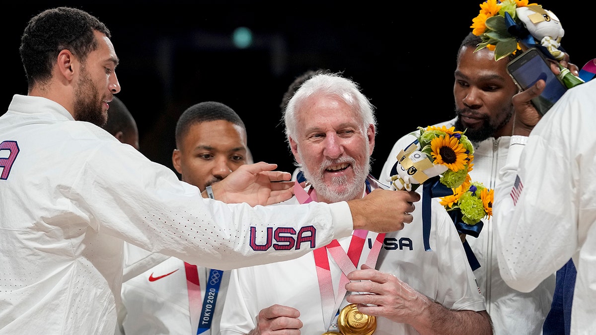 U.S. basketball players each put a gold medal on coach Gregg Popovich during the men's basketball medal ceremony at the 2020 Summer Olympics on Saturday, Aug. 7, 2021 in Tokyo.