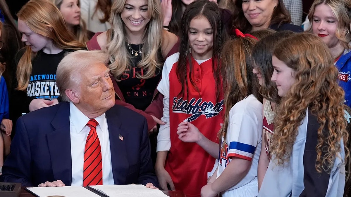 President Donald Trump signs an executive order with young female athletes banning transgender women from competing in women/girls sporting events on Feb. 6, 2025.