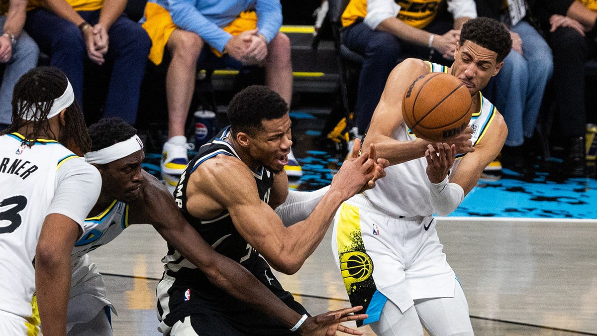 Giannis Antetokounmpo and Tyrese Haliburton fight for loose ball
